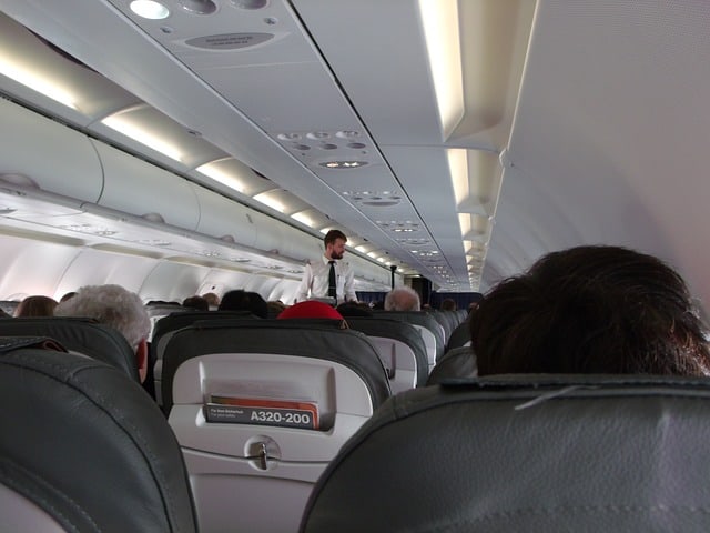 tall flight attendant on airplane 